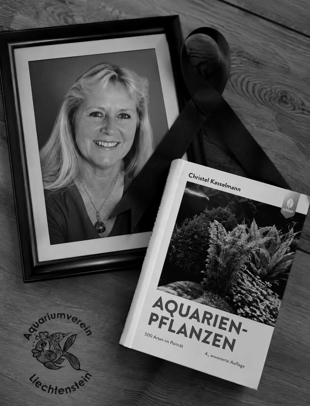 Herdenkingsbeeld met een portret van Christel Kasselmann, een rouwlint en haar boek Aquarienpflanzen